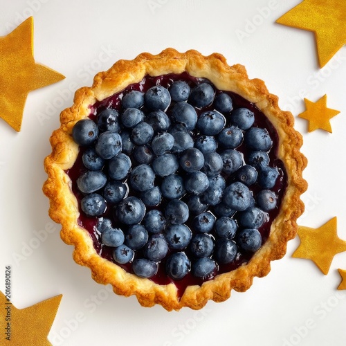 Blueberry Tart Sits on White Surface Surrounded by Star-Shaped Cookies on a S...