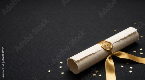 Graduation and academic achievement concept with rolled diploma on dark background. Successful completion of studies, university degree and professional certification recognition.