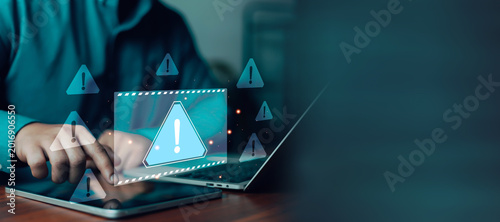 Photos Cybersecurity warning alert interface with user using tablet and laptop, illustrating online security risk, data protection, phishing attack, malware detection, and digital privacy concept