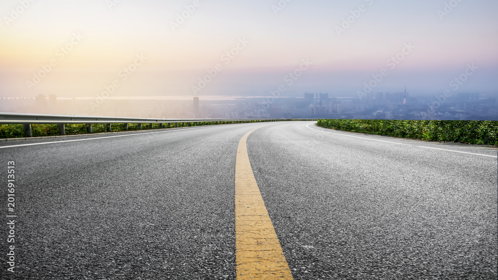Naklejka premium Curved Asphalt Highway Overlook At Dusk Over City