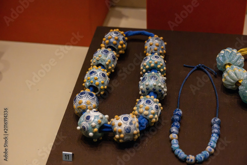 Fotografie Veria, Greece - 16 Aug 24: Ancient blue glass beads necklace displayed at Veria