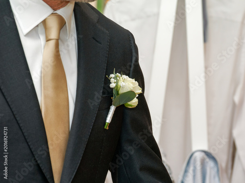 Cuadro en lienzo Détail du costume du marié avec boutonnière florale et cravate dorée