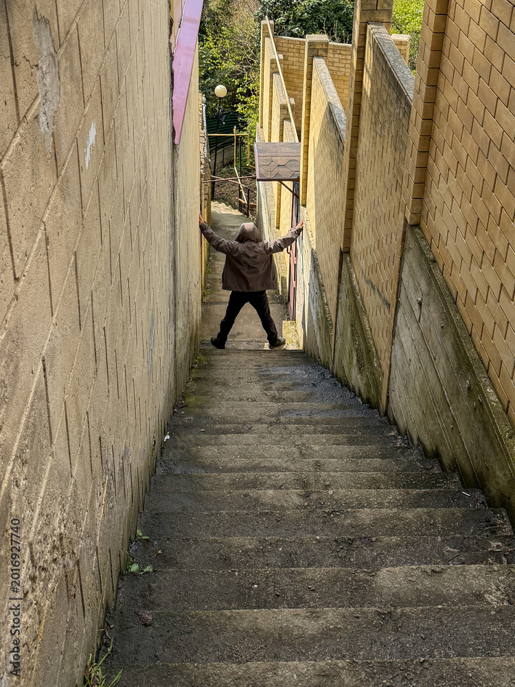 Fototapeta premium Man stands at top of steep concrete stairs