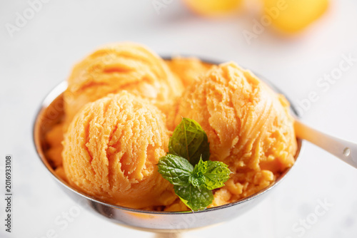 Natural fruit orange ice cream or sorbet in ceramic bowl