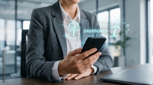 Businessman holding smartphone with glowing dashboard and renewable energy icons. Smart business analytics, cloud technology, and sustainable enterprise concept.