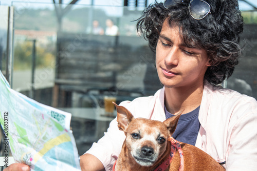 Fotografia Young traveler with his dog looking at a map and deciding which direction to tak