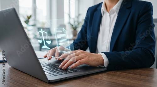 Lawyer using laptop with holographic scales and legal document icons. Digital law practice, legal technology, and online compliance concept.