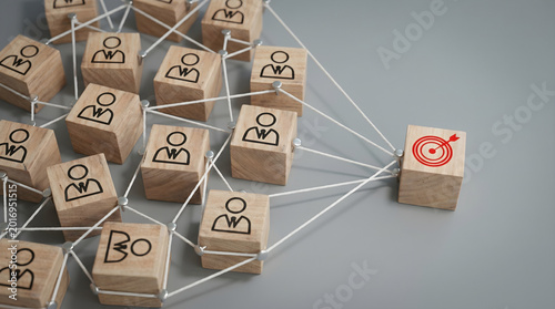 White strings connect several wooden blocks with professional icons to a central red target. This layout represents a team unified by a singular objective.
