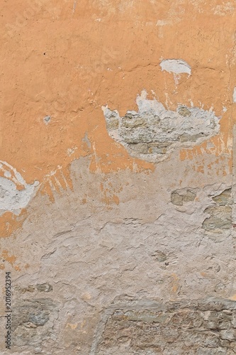 фотографія Deteriorating exterior wall with several visible layers of building materials with cracked and peeling plaster, exposing the rough stone underneath, Saaremaa, Estonia, Europe