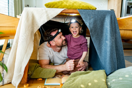 Fotografie Dad and child building and playing in cozy blanket fort.