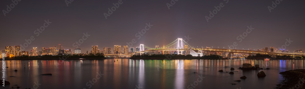 Fototapeta premium Panoramic Night Skyline with Illuminated Suspension Bridge