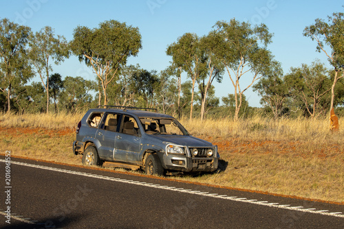 An old car in the Australian bush, rusty and abandoned by the side of the road.