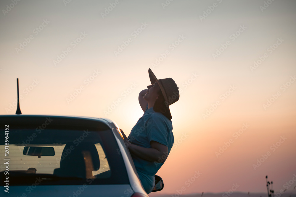 Naklejka premium Girl with hat in the window of the car. Adventure, vacation, road trip concept.
