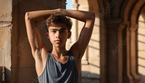 Young Male Teenager Wearing Sleeveless Shirt Standing Outdoors Near Historic Stone Architecture