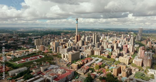 4K drone orbit establishing shot of Hillbrow district and tower in Johannesburg. South African urban landscape featuring dense city architecture and iconic landmark skyline panorama.