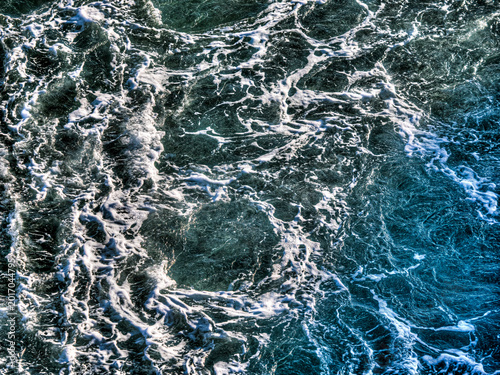 Fotografie Ocean waves churning creating white sea foam texture