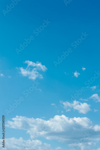 Clear blue sky with scattered white clouds