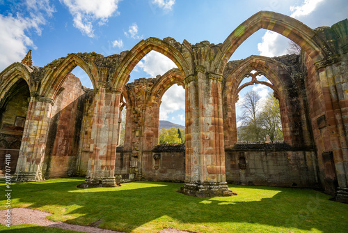 Foto A series of massive Gothic stone arches inside the former nave of Melrose Abbey, a former Cistercian monastery in Melrose, Scotland