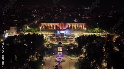 Night drone orbit around Chisinau Cathedral Park and concert crowd near government building