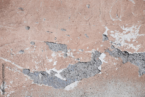 Peeling paint plaster wall with exposed concrete texture and weathered surfac...