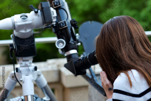 Schilderij op canvas Person looking through an astronomical telescope eyepiece in a close up view, demonstrating amateur astronomy equipment in use