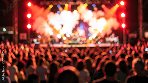 Energetic crowd at a live music concert with dramatic stage lighting