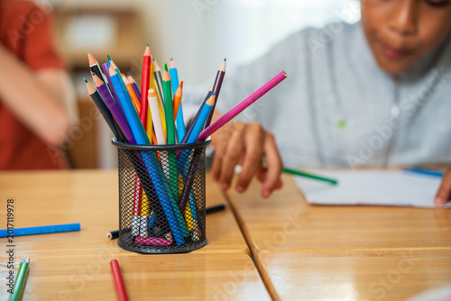 Colorful pencils in the classroom. Jars of colored pencils for an elementary school art class. Holder with colorful pencils on classroom table 
