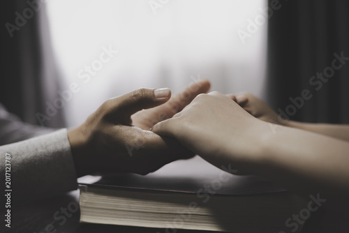 Canvas Print Christian group of people holding hands praying worships together to believe and Bible on wooden table for devotional for prayer meeting