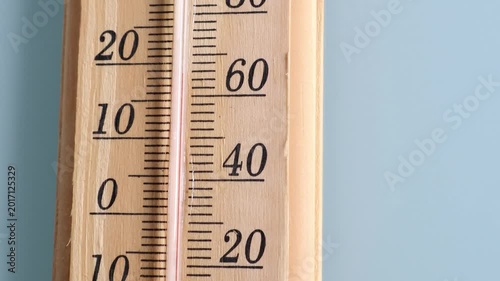 A wooden thermometer with a gray background and copy space