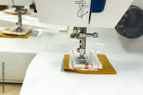 Foto Close up of electric sewing machine needle stitching textile material