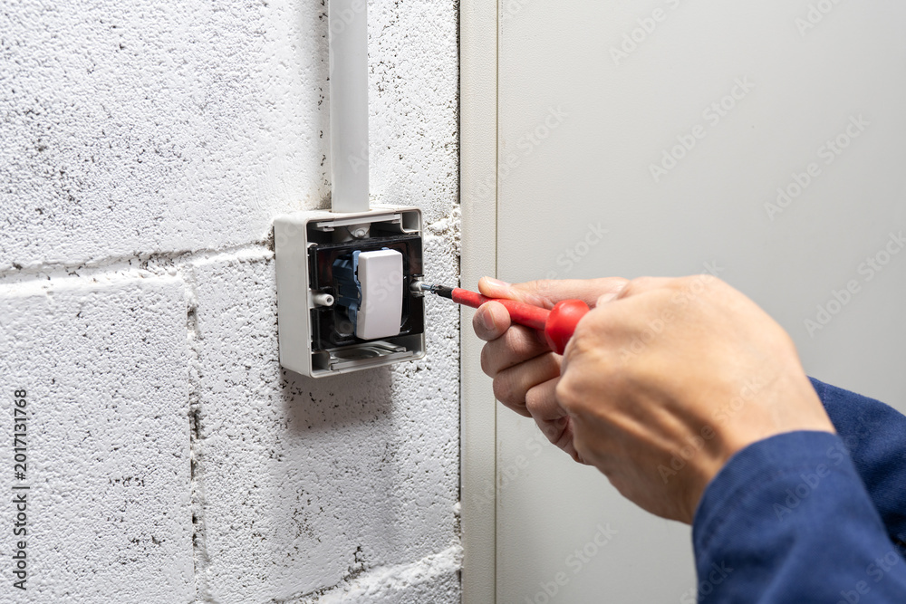 Φωτογραφία Electrician mounting electric sockets on the white wall