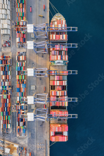 Obraz na plátně Overhead aerial view of a super container ship being unloaded by crynes in a com