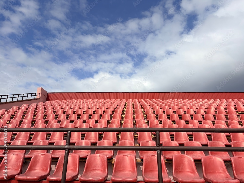 Fototapeta premium an open sports stadium with rows of red plastic seats without people