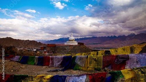 Gompa, Iconic landmark over looking Leh in Himalaya mountains, with colourful Tibetan prayer flags in foreground, dynamic tracking motion time lapse with dramatic cloud.