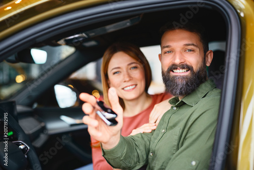 Man holding car keys after buying new vehicle at dealership