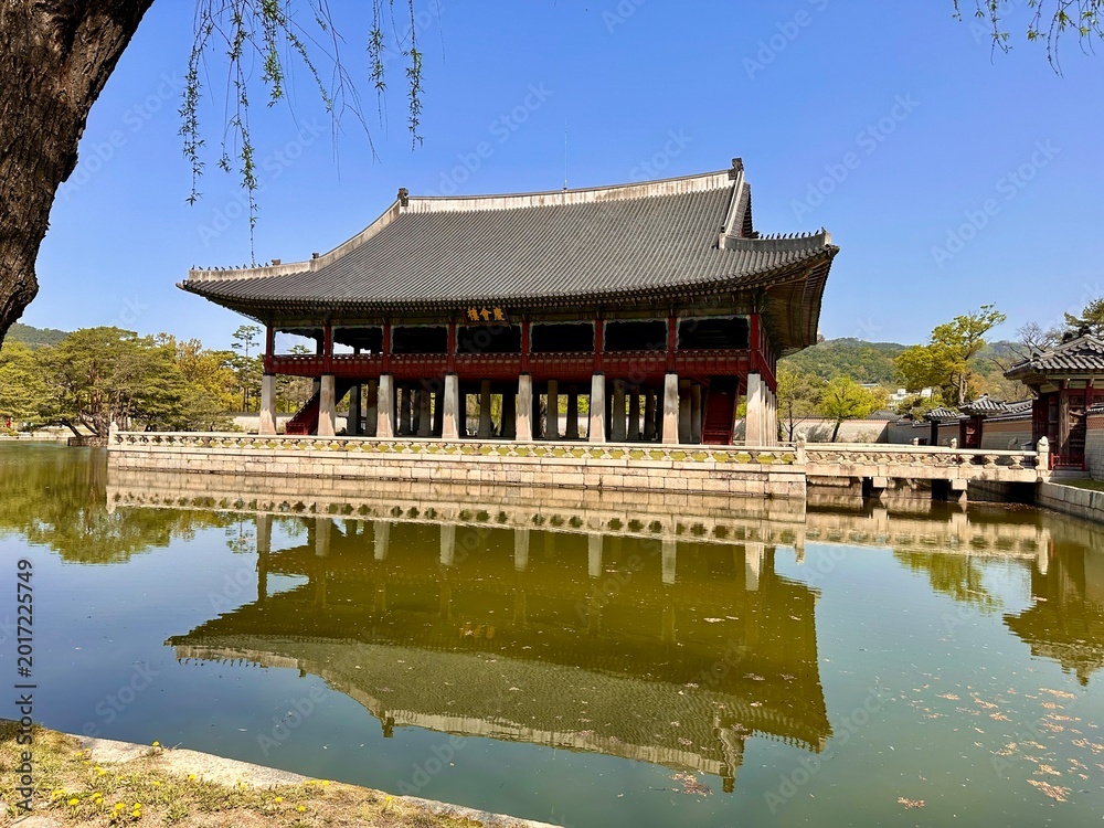 Fototapeta premium Historic building stands by the water with reflection during a clear day in a traditional location