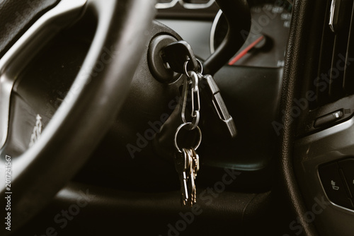 Car ignition with keys hanging from the steering column, ready to start