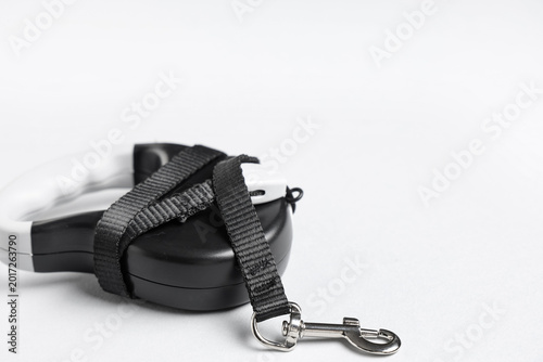 Fotografie Black retractable dog leash with lead on grey background, closeup