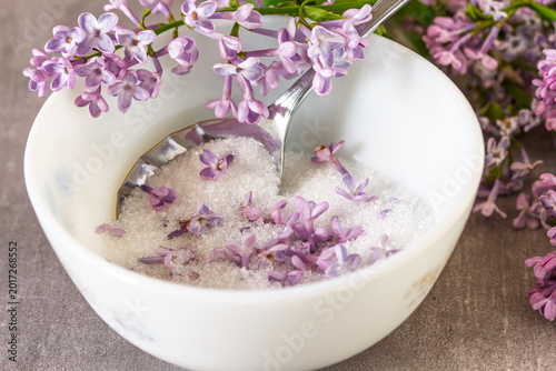 Foto Purple lilac flowers in sugar with fresh flowers and vintage spoon