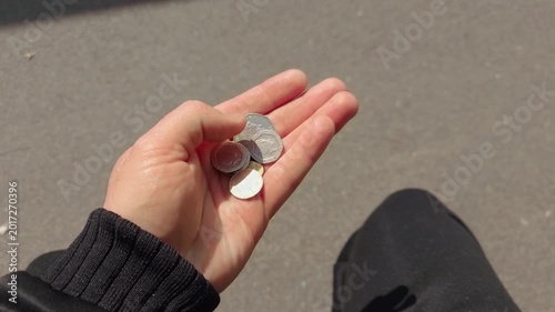 Hand counting British coins in natural sunlight from first person perspective. Personal finance, budgeting, small change money concept with UK currency held outdoors. Everyday expenses, savings