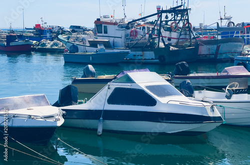 Photos Colorful traditional fishing boats moored in the calm, reflective water of Setubal harbor, Portugal