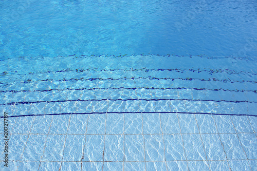 Blue pool filled with water in Summer
