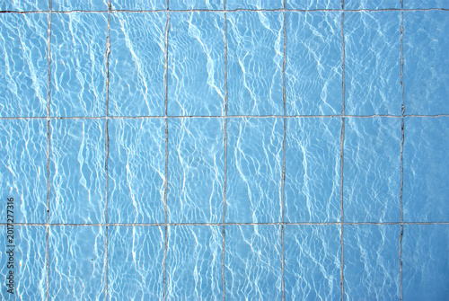 Blue pool filled with water in Summer