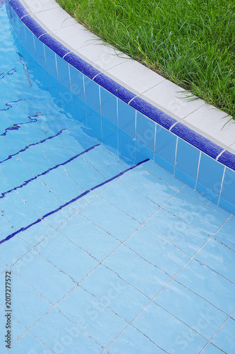 Blue pool filled with water in Summer