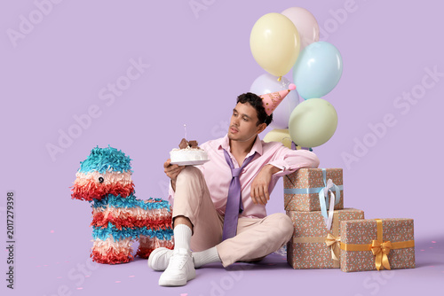 Sad young man with cake and...