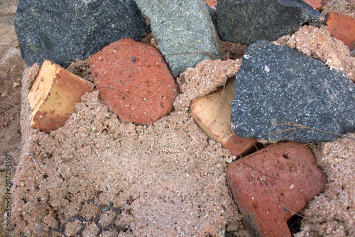 Foto Broken bricks and stone rubble set in coarse sandy mortar, showing texture, decay and construction debris ideal for backgrounds, renovation, demolition and building material concepts