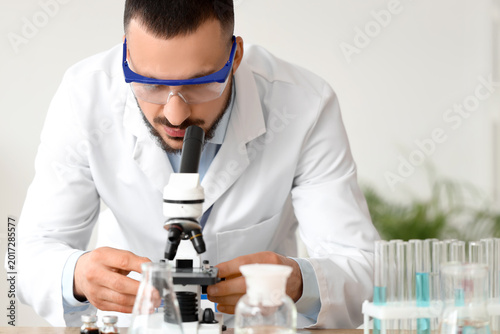 Male scientist looking thro...