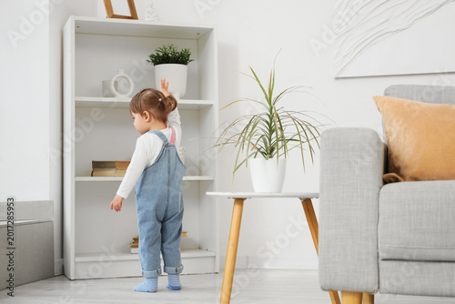 Cute little girl near shelf...