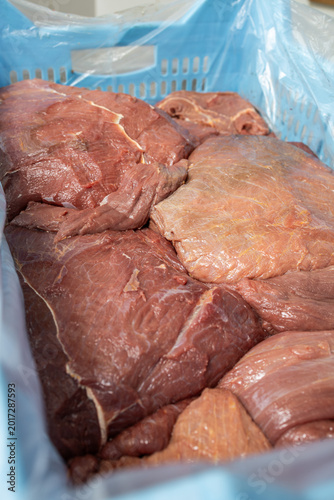 Raw beef primal cuts in blue industrial crate
