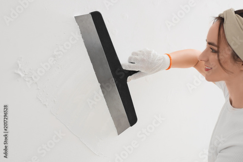 Young woman with putty knif...